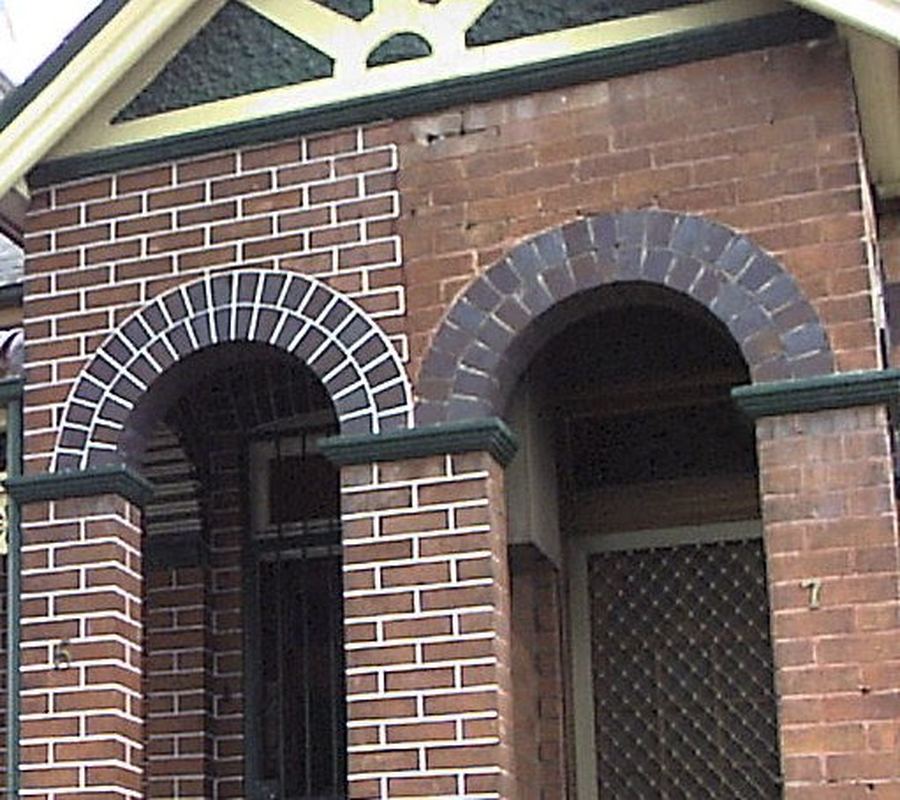 Federation brick porch arches after repointing, under a decorative timber frieze