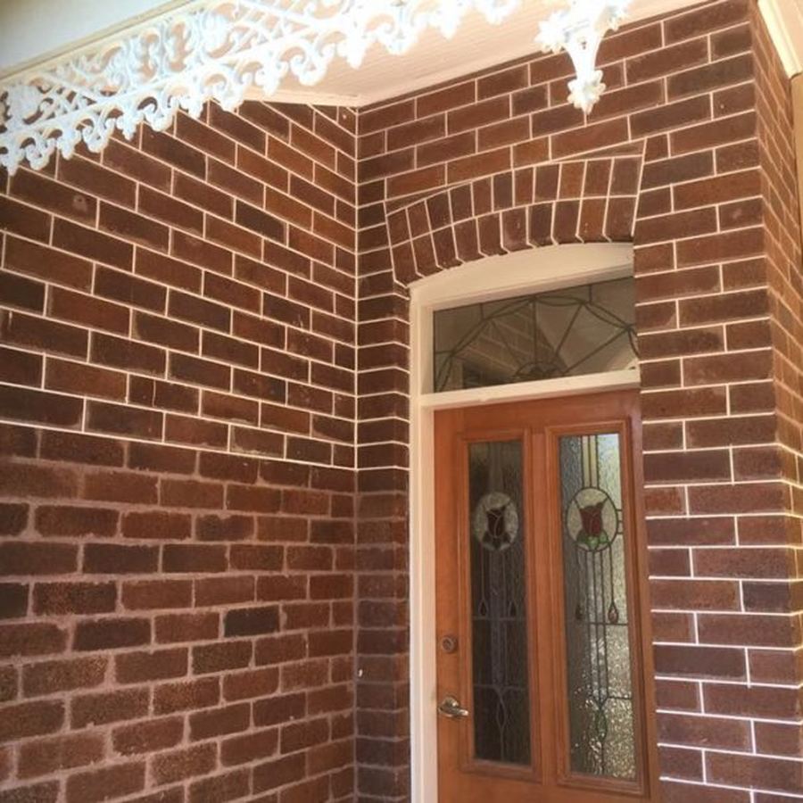 Repointed Federation brickwork around a leadlight front door