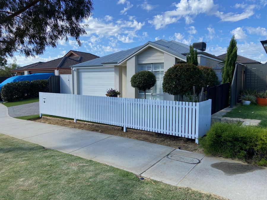 White picket fence along the front of a new house